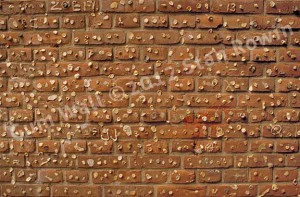 Photo of a red brick wall of chewing gum deposits